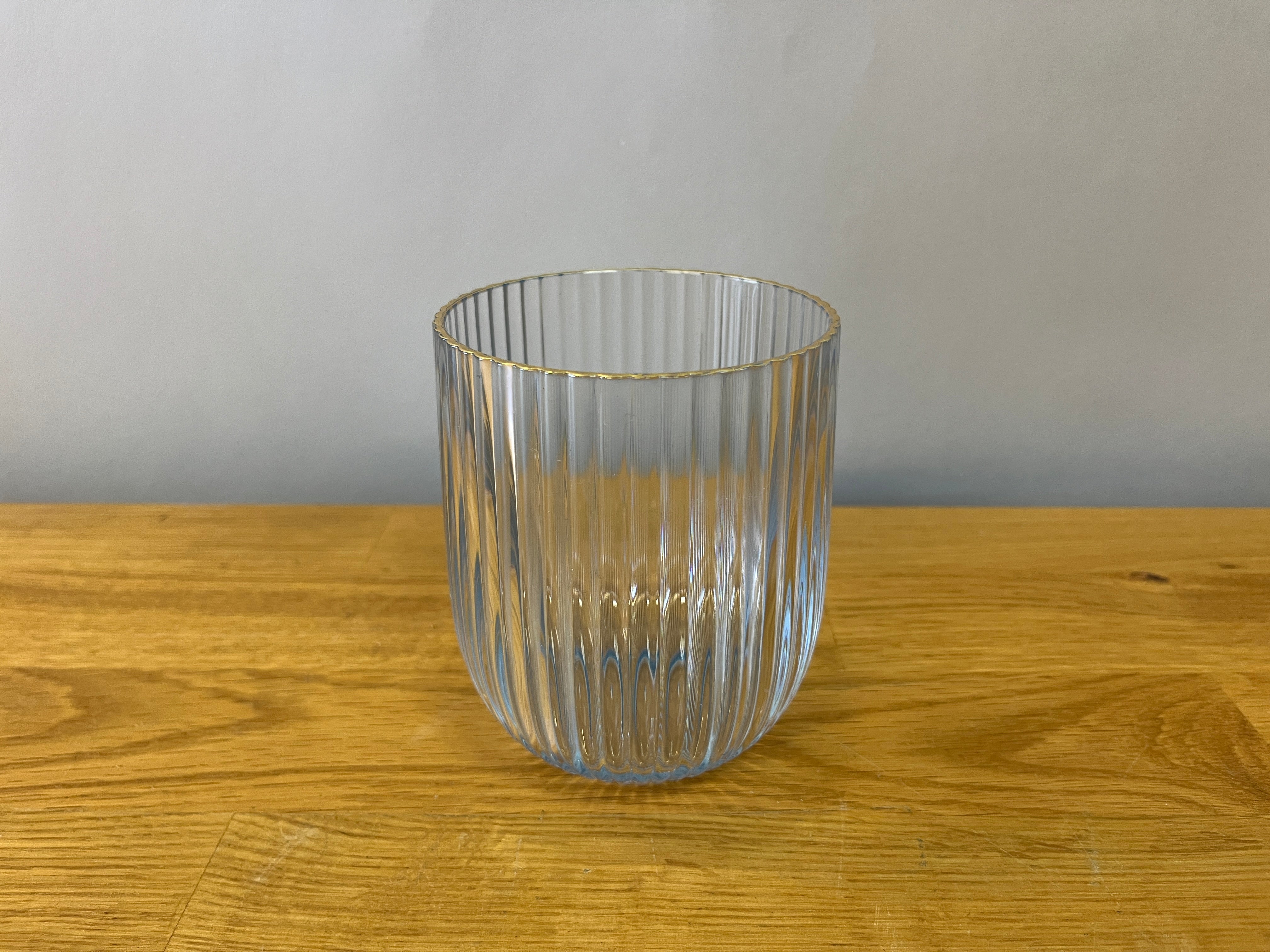 plastic fluted drinking glass with a blue tone and gold edge
