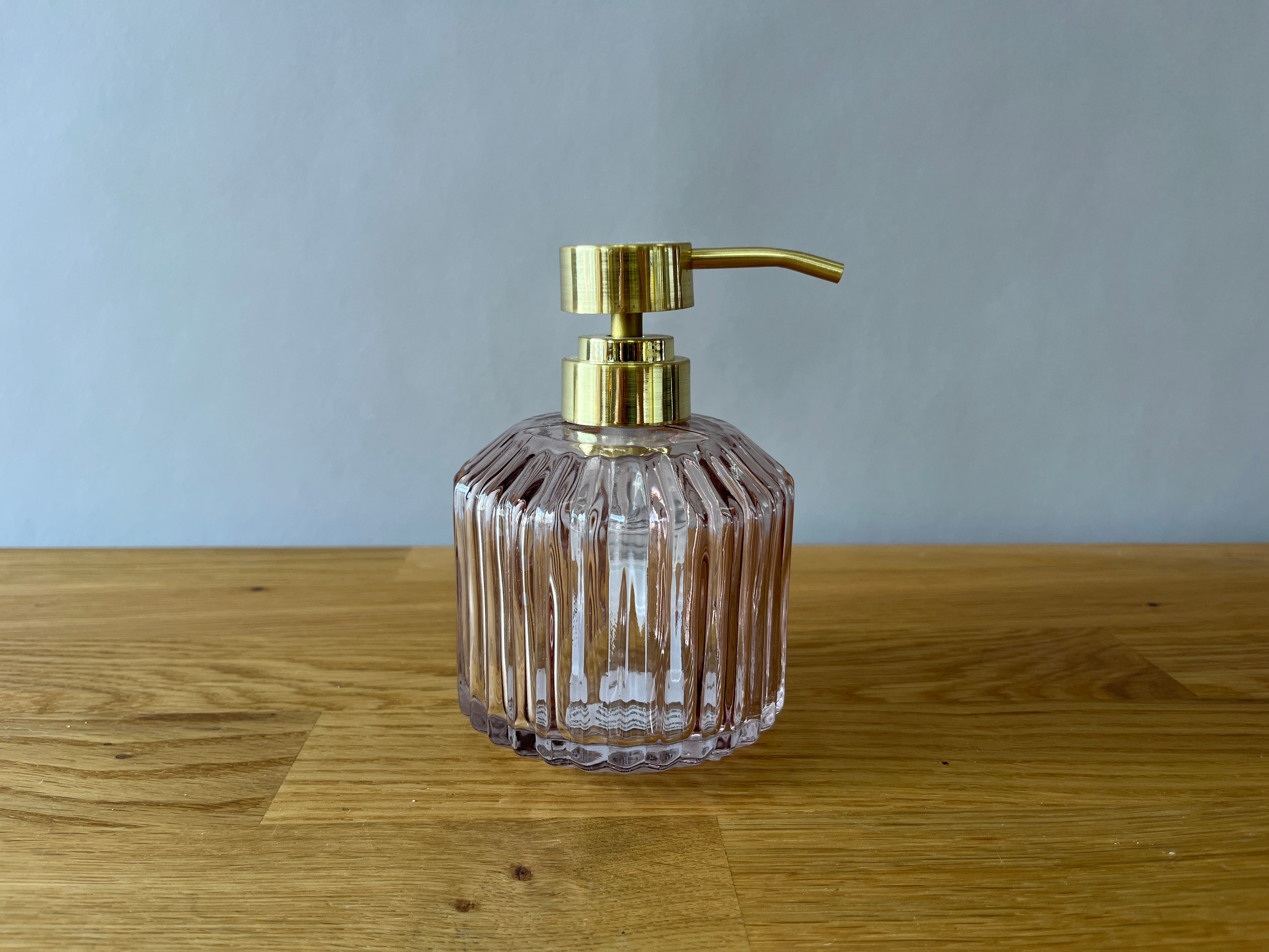 pink fluted glass soap dispenser with gold top